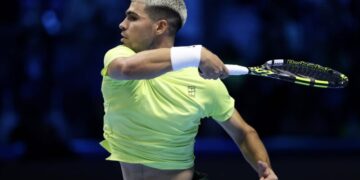 TURIN, ITALY - NOVEMBER 09: Carlos Alcaraz of Spain plays a forehand against Alex de Minaur of Australia during the Group Stage match on day one of the Nitto ATP Finals 2025 at Inalpi Arena on November 09, 2025 in Turin, Italy. (Photo by Clive Brunskill/Getty Images)