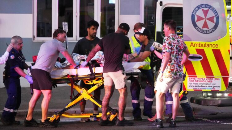 Emergency workers transport a person on a stretcher after a reported shooting at Bondi Beach in Sydney, Sunday, Dec. 14, 2025. (AP Photo/Mark Baker) (Emergency workers transport a person on a stretcher after a reported shooting at Bondi Beach in Sydne