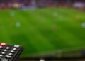 Aficionados siguiendo en televisión la agenda deportiva del fin de semana con F1, Tour de Francia, Wimbledon y Mundial