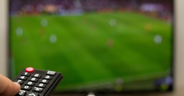 Aficionados siguiendo en televisión la agenda deportiva del fin de semana con F1, Tour de Francia, Wimbledon y Mundial